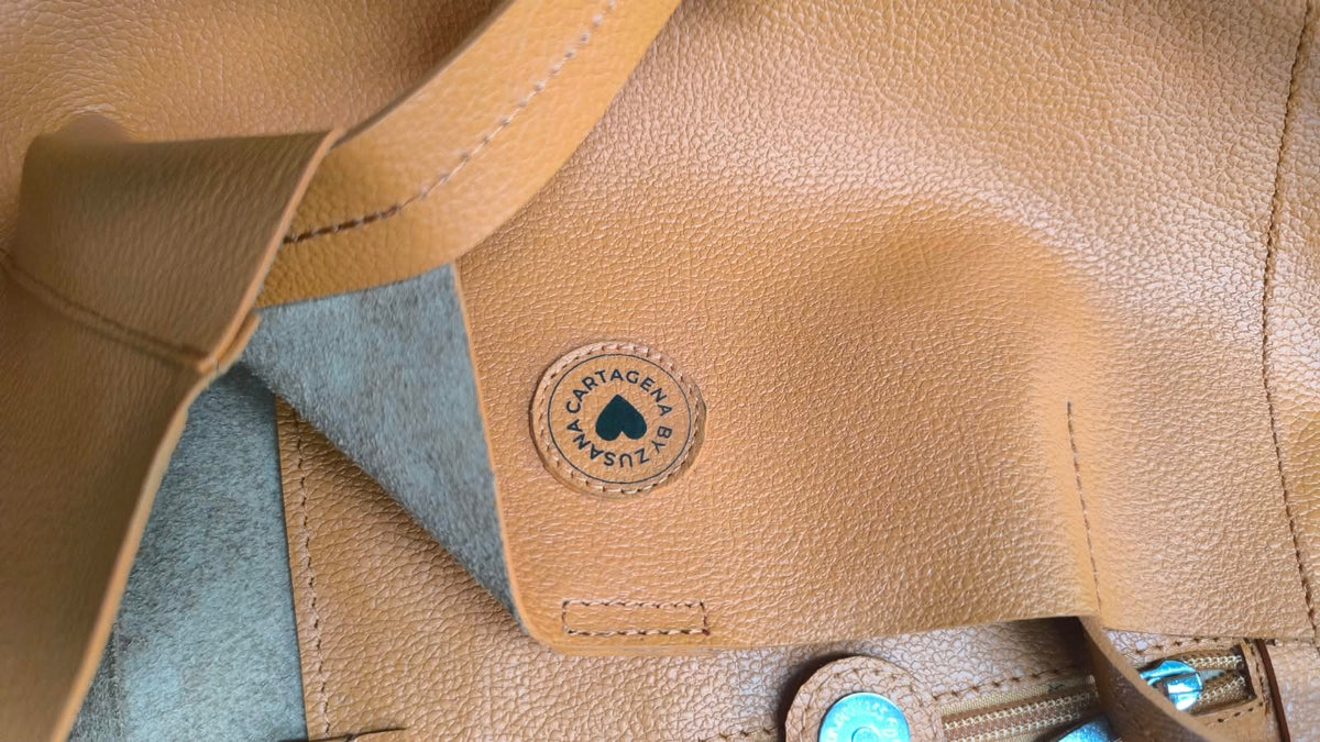 Close up of a leather tote bag showing the leather details, the top grain and the bak swede to showcase the quality